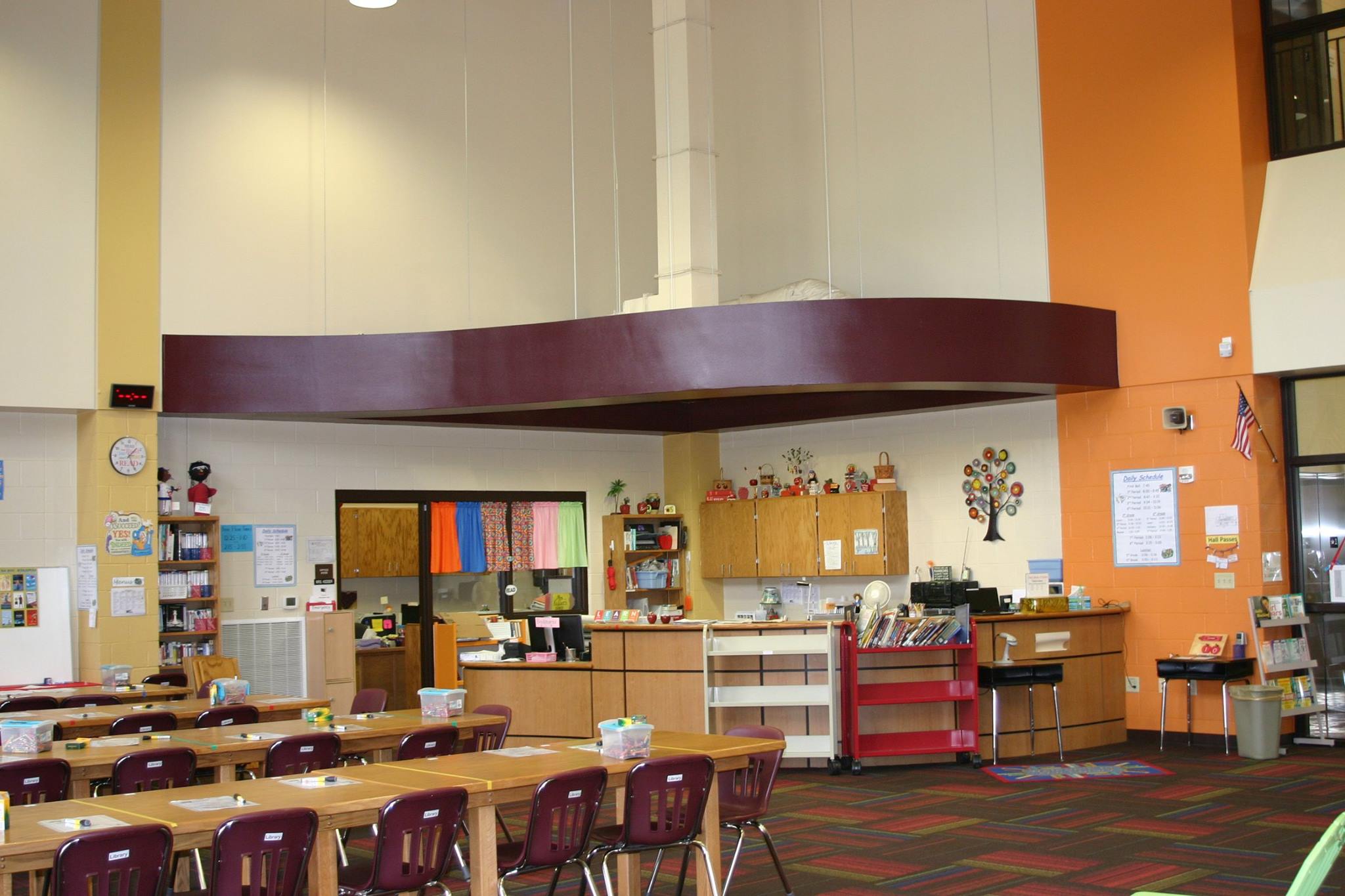large librarian's deck and tables for students in school library